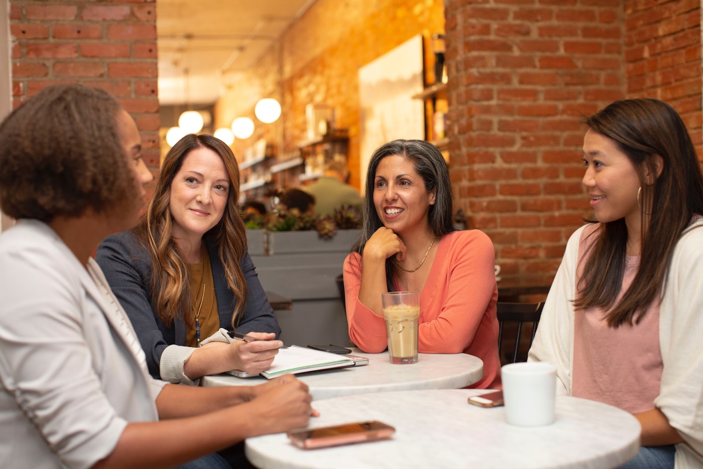Een diverse groep mensen in gesprek aan een cafétafel